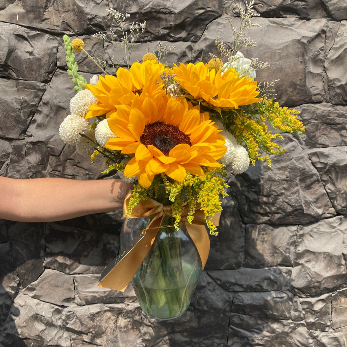 Florero con girasoles y variedad floral