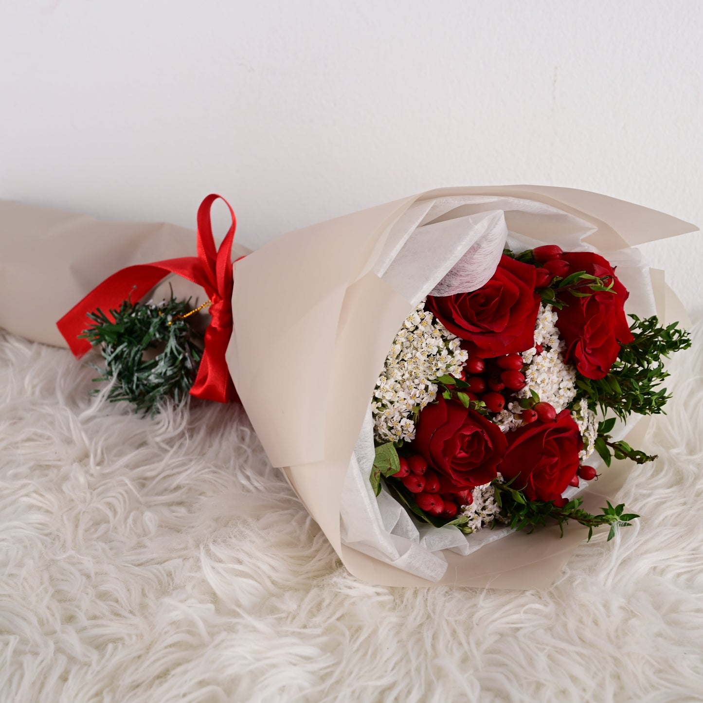 Ramo navideño de 4 rosas rojas con achilea y variedad floral
